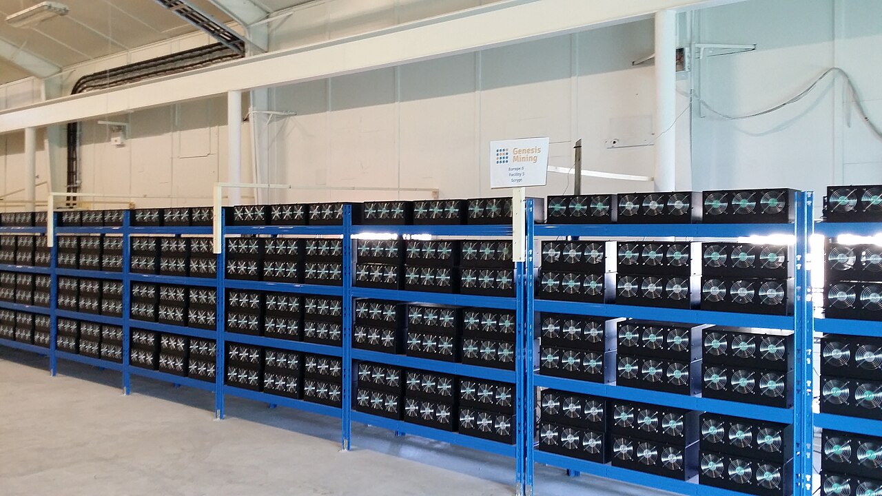 Rows of cryptocurrency mining machines on blue metal shelving in a warehouse